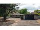 Charming single-level home with a well-kept lawn, mature trees, and modern black garage door at 2175 S Joliet St, Aurora, CO 80014