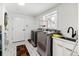Functional laundry room featuring modern appliances, stylish tile floors, and ample counter space at 2175 S Joliet St, Aurora, CO 80014