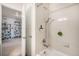 Clean bathroom with a shower-tub combo, white tile, and adjacent access to a movie collection at 2243 Villageview Ln, Castle Rock, CO 80104