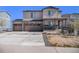 Charming two-story home featuring a stone facade, three-car garage, and covered front porch at 2243 Villageview Ln, Castle Rock, CO 80104
