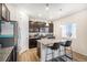 Bright kitchen with dark cabinets, an island with seating, stainless appliances, and wood grain flooring at 2243 Villageview Ln, Castle Rock, CO 80104