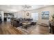 Open concept living room with hardwood floors, a large sectional sofa, and connected kitchen area at 2243 Villageview Ln, Castle Rock, CO 80104