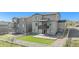 Rear exterior view of a multi-story home with a balcony, concrete patio, artificial lawn, and privacy fence at 2243 Villageview Ln, Castle Rock, CO 80104