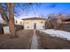 A backyard view with a white house, fence, storage shed, and a path leading to the back door at 1901 S Lincoln St, Denver, CO 80210