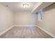 A cozy basement room with neutral walls and carpet, illuminated by a flush mount light fixture at 1901 S Lincoln St, Denver, CO 80210