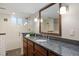 Updated bathroom featuring a granite-topped vanity, a large mirror, and a glass-enclosed shower at 1901 S Lincoln St, Denver, CO 80210
