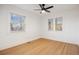 Empty bedroom featuring hardwood floors, neutral walls, ceiling fan, and three windows at 1901 S Lincoln St, Denver, CO 80210