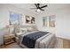 A staged bedroom features natural light, a large bed, neutral decor, and a ceiling fan at 1901 S Lincoln St, Denver, CO 80210