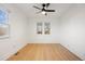 Sunlit bedroom boasts hardwood floors, neutral paint, and a ceiling fan for comfort at 1901 S Lincoln St, Denver, CO 80210