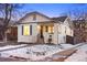 Charming white brick home with a front porch and landscaped yard in winter at 1901 S Lincoln St, Denver, CO 80210