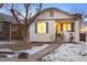 Home features white brick, blue shutters, covered porch, and some snow on the ground at 1901 S Lincoln St, Denver, CO 80210