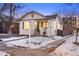 Charming white brick home with a front porch, stairs, and landscaped yard in winter at 1901 S Lincoln St, Denver, CO 80210