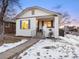 Charming bungalow with white brick exterior, snowy front yard, and inviting front porch at 1901 S Lincoln St, Denver, CO 80210