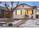 Beautiful home with a covered front porch, black iron railings, and snowy landscaping at 1901 S Lincoln St, Denver, CO 80210