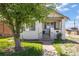 A white brick home features a porch and manicured front yard at 1901 S Lincoln St, Denver, CO 80210