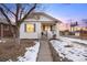 Charming bungalow with a freshly painted exterior and snowy lawn at 1901 S Lincoln St, Denver, CO 80210