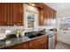 Granite countertops and stainless steel appliances adorn this modern kitchen with wood cabinets and bright lighting at 1901 S Lincoln St, Denver, CO 80210
