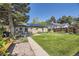 Lush backyard featuring a well-manicured lawn, patio area, with outdoor seating, and solar panels at 2844 Bellaire St, Denver, CO 80207