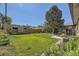 Expansive backyard with lush green grass, mature trees, and a patio seating area at 2844 Bellaire St, Denver, CO 80207