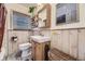 Charming bathroom with wood-paneled walls, stylish sink, and natural light at 2844 Bellaire St, Denver, CO 80207