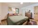 Cozy bedroom featuring a comfortable bed, wood floors, and natural light from the window at 2844 Bellaire St, Denver, CO 80207