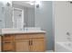 Well-lit bathroom with a white-tiled shower-tub combo, light wood vanity, and ample counter space at 3890 S Dayton St # 105, Aurora, CO 80014