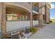 Close-up of condo building with brick facade, ground floor patio, and A/C units at 3890 S Dayton St # 105, Aurora, CO 80014