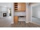 Built in home office space with wood cabinets and view of the living room fireplace at 3890 S Dayton St # 105, Aurora, CO 80014
