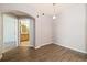 Living area with wood-look flooring leading to an arched entryway and bright bathroom at 3890 S Dayton St # 105, Aurora, CO 80014