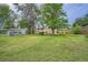 Large backyard with a lush green lawn and mature trees at 5274 Alkire St, Arvada, CO 80002