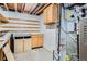 Unfinished basement with cabinets, shelving, and a water heater at 5274 Alkire St, Arvada, CO 80002