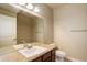 Well-lit bathroom features granite counters, a large mirror, and tiled shower surround at 15265 W Baker Ave, Lakewood, CO 80228
