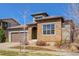Charming stone-accented home featuring a tile roof and well-maintained landscaping at 15265 W Baker Ave, Lakewood, CO 80228