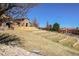 Home exterior with tiered lawn and mature trees at 15265 W Baker Ave, Lakewood, CO 80228