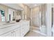 Elegant bathroom featuring a double vanity, framed mirrors, and a walk-in shower at 23782 E 33Rd Pl, Aurora, CO 80019