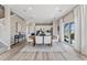 Bright dining area features wood floors, a modern table and seating, leading to a kitchen and outdoor area at 23782 E 33Rd Pl, Aurora, CO 80019