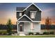 Charming two-story home featuring vertical siding and stone accents, set against a picturesque sunset backdrop at 23782 E 33Rd Pl, Aurora, CO 80019