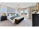 Comfortable main bedroom with blue accents, light-filled windows, and stylish chandelier at 23782 E 33Rd Pl, Aurora, CO 80019