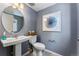 Charming powder room with a pedestal sink, round mirror, and stylish wall art at 23782 E 33Rd Pl, Aurora, CO 80019