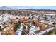 Aerial view featuring a neighborhood with apartments, winter trees, and snow against a mountain backdrop at 3305 S Ammons St # 202, Lakewood, CO 80227