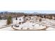 Snowy winter aerial view of a residential area with winding paths and bare trees, set against a backdrop of distant mountains at 3305 S Ammons St # 202, Lakewood, CO 80227