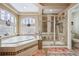 Beautiful bathroom featuring soaking tub, glass enclosed shower, and mosaic tile accents at 5293 Malaya St, Denver, CO 80249