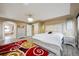 Bright bedroom featuring modern furnishings, red and gold rug, tray ceiling, and connecting bathroom at 5293 Malaya St, Denver, CO 80249