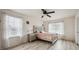 Well-lit bedroom featuring laminated wood floors, ceiling fan, and large windows at 5293 Malaya St, Denver, CO 80249