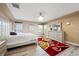 Spacious bedroom featuring light gray wood floors, decorative red and gold rug, and a tray ceiling with chandelier at 5293 Malaya St, Denver, CO 80249