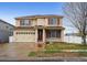 Charming two-story home featuring red shutters, a well-maintained lawn, and an attached two-car garage at 5293 Malaya St, Denver, CO 80249