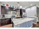 Modern kitchen featuring stainless steel appliances, dark wood cabinets, and a large granite island at 8321 E 33Rd Ave, Denver, CO 80238