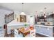 Bright dining area and kitchen featuring dark cabinets, stainless steel appliances, and modern lighting at 8321 E 33Rd Ave, Denver, CO 80238