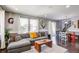 Spacious living room with gray sofa, a wood coffee table, and large windows for natural light at 8321 E 33Rd Ave, Denver, CO 80238
