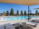 Community pool featuring lounge chairs, tables, umbrellas, and a lifeguard stand on a clear, sunny day at 8321 E 33Rd Ave, Denver, CO 80238
